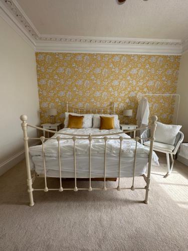 een slaapkamer met een wit bed en een gele muur bij Seaside Retreat No 8 in Ayr