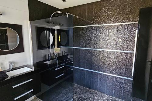 La salle de bains noire est pourvue d'une douche et d'un lavabo. dans l'établissement villas-majos : Splendide Villa proche Pinarello, plages à pied., à Sainte-Lucie de Porto-Vecchio
