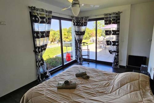 une chambre avec un grand lit et une grande fenêtre dans l'établissement villas-majos : Splendide Villa proche Pinarello, plages à pied., à Sainte-Lucie de Porto-Vecchio