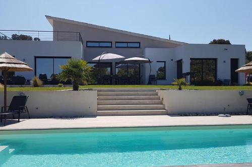 une maison avec une piscine devant une maison dans l'établissement villas-majos : Splendide Villa proche Pinarello, plages à pied., à Sainte-Lucie de Porto-Vecchio