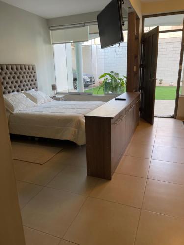 ein Schlafzimmer mit einem Bett und einem TV in der Unterkunft Apart-hotel Villakayro in Moquegua