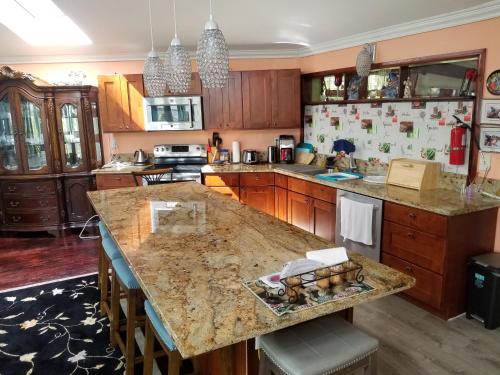 a kitchen with a large island with a counter top at Fully renovated 4 bd with 2 master suits, 3 bth home in centralized location in Keaau