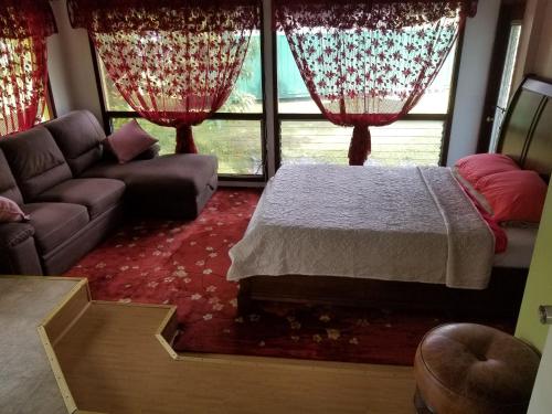 a living room with a bed and a couch at Fully renovated 4 bd with 2 master suits, 3 bth home in centralized location in Keaau