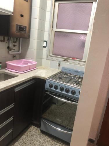 a kitchen with a stove and a sink and a window at Mar del plata in Mar del Plata