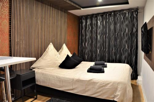a bedroom with a white bed with a black curtain at Apartments Am Werdersee in Bremen