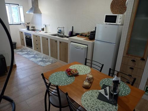 uma cozinha com uma mesa e cadeiras e um frigorífico em Casa25 em Alenquer