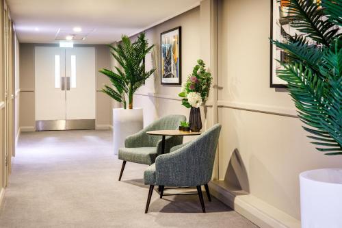 a waiting room with two chairs and a table at Holiday Inn Milton Keynes Central by IHG in Milton Keynes