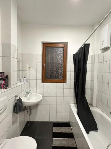 a bathroom with a sink and a tub and a toilet at Duisburg FeelHome, Flughafen nah, 6 Personen, Badewanne, Zentral, WiFi, Ground Floor in Duisburg