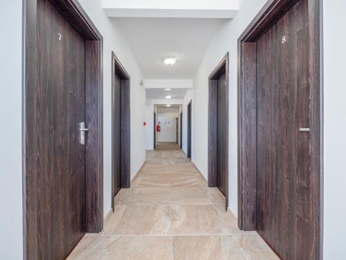 a corridor with wooden doors in a hallway at Penzion ARIES in Nitra