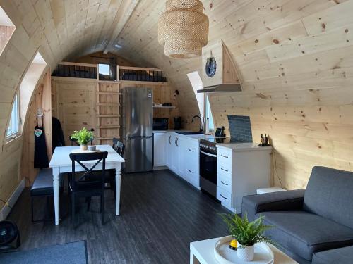 una cocina y sala de estar en una casa pequeña en Le POD'Stress / Nature et tranquilité en Saint-Alexis-des-Monts