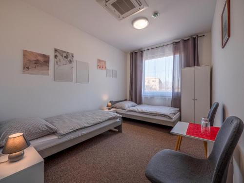 1 dormitorio con cama, escritorio y ventana en Penzion ARIES en Nitra