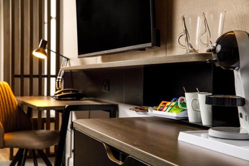 a kitchen with a counter with a desk and a tv at Holiday Inn Milton Keynes Central by IHG in Milton Keynes