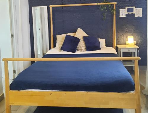 a bed with a wooden frame with two pillows on it at Bonito Alojamiento F in Valencia