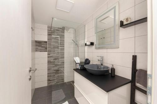 a bathroom with a sink and a glass shower at Deluxe Apartments 55 in Rateče