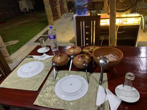 a wooden table with white plates and spoons on it at Serendip Villa Holiday HomeTalalla Sri Lanka in Matara