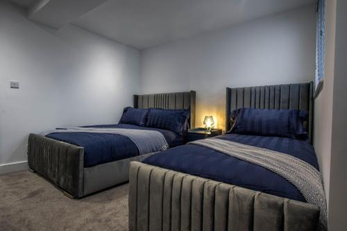 a bedroom with two beds with blue pillows at River View Luxury Apartment in Littlehampton