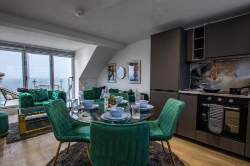 a living room with a table and green chairs at River View Luxury Apartment in Littlehampton