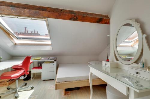 - une chambre avec un bureau, un miroir et une chaise rouge dans l'établissement Duplex calme et lumineux au cœur de Bastille, à Paris