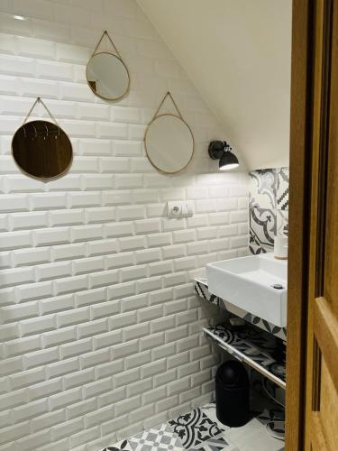 une salle de bain avec un lavabo et deux miroirs au mur dans l'établissement Le Néo au 17, appartement cosy dans le centre historique de Rodez, à Rodez