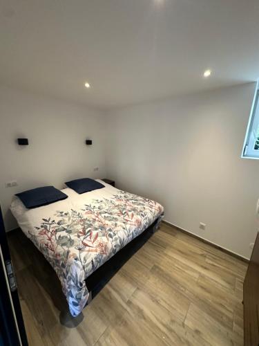 a bedroom with a bed with a floral bedspread at appartement moderne et confort in Châtillon-sur-Seine