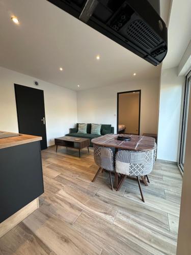 a living room with a table and a couch at appartement moderne et confort in Châtillon-sur-Seine