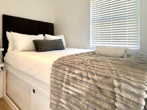 a bedroom with a large bed with a blanket on it at The Saasveld in Cape Town
