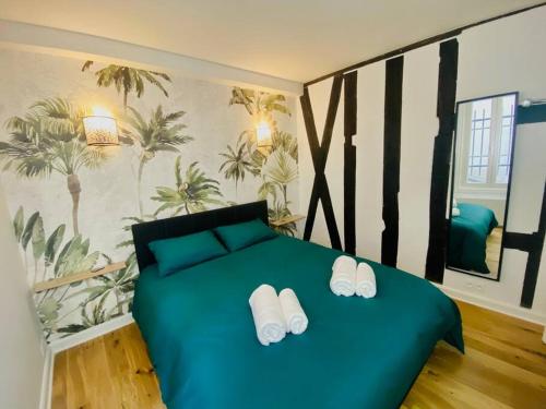 um quarto com uma cama verde e chinelos em Lovely studio in the Heart of St Germain-des-Prés em Paris