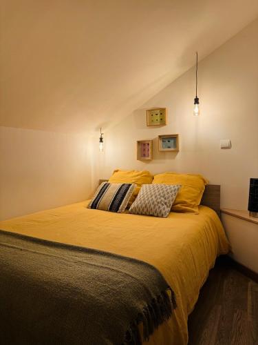 - une chambre dotée d'un grand lit avec des draps jaunes dans l'établissement Le Néo au 17, appartement cosy dans le centre historique de Rodez, à Rodez