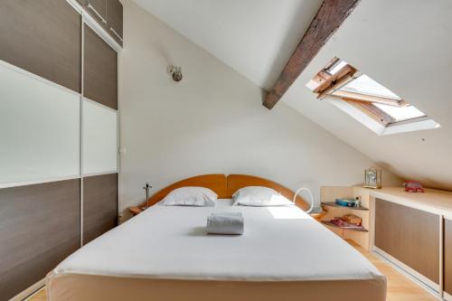 une chambre avec un lit et une lucarne dans l'établissement Duplex calme et lumineux au cœur de Bastille, à Paris