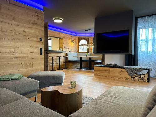 ein Wohnzimmer mit Sofa und Fernseher in der Unterkunft woidpanorama Ferienwohnungen in Neuschönau