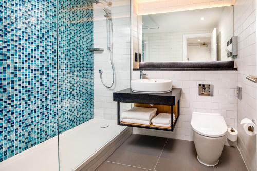 a bathroom with a sink and a toilet and a shower at Holiday Inn Milton Keynes Central, an IHG Hotel in Milton Keynes