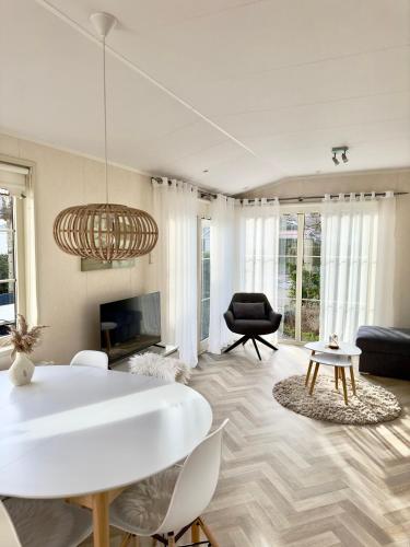 a living room with a white table and chairs at Chalet Sirun Strandcamping Valkenisse, Biggekerke in Biggekerke