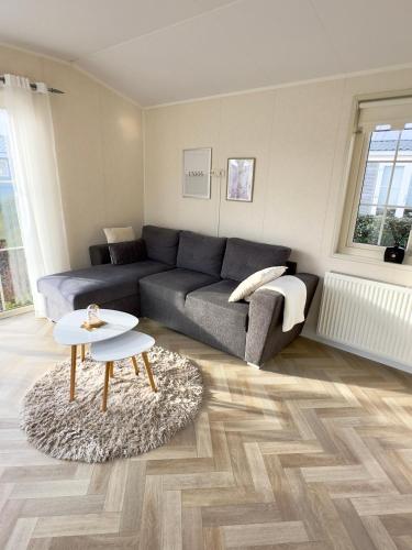 a living room with a couch and a table at Chalet Sirun Strandcamping Valkenisse, Biggekerke in Biggekerke