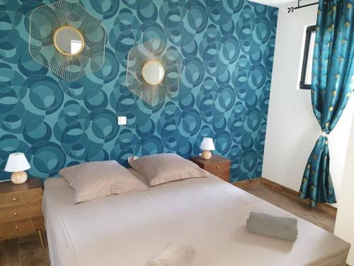 une chambre avec un lit avec un mur bleu dans l'établissement villas-majos : Superbe bergerie vue mer montagne piscine chauffée, à Sainte-Lucie de Porto-Vecchio