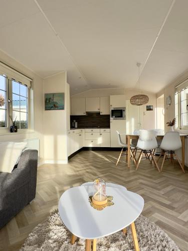 a living room with a couch and a table at Chalet Sirun Strandcamping Valkenisse, Biggekerke in Biggekerke