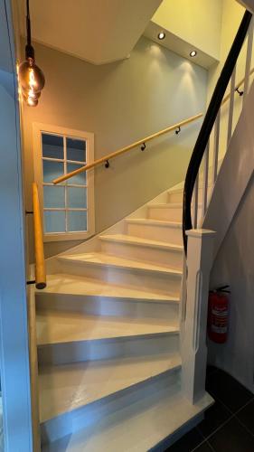 una escalera en una casa con escaleras blancas en Bedroom, livingroom and separate bathroom, en Fredrikstad