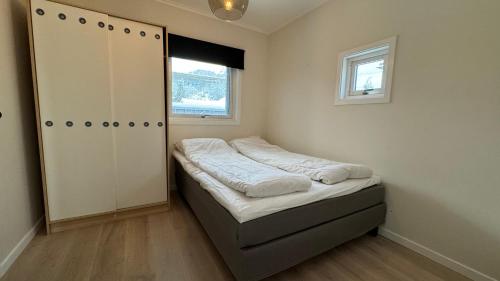 a small bedroom with a bed and a window at Bedroom, livingroom and separate bathroom in Fredrikstad