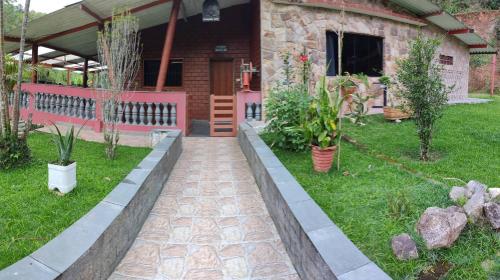 Chácara, 3 suítes, piscina, lago, wi-fi 250 mbps في جوارولوس: حديقة بها نباتات الفخار أمام المنزل