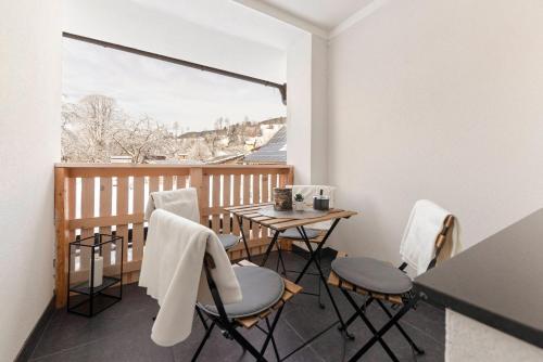 balcón con mesa, sillas y ventana en Deluxe Apartments 55 en Rateče