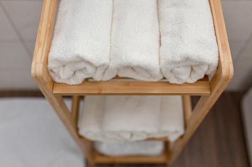 a towel rack with white towels on it at Deluxe Apartments 55 in Kranjska Gora