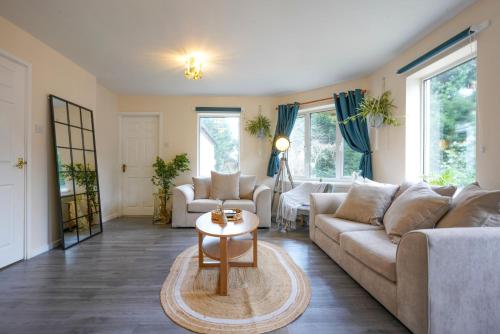 a living room with a couch and a table at Orchard Bungalow - Sleeps 10 - Close to Town Centre - Free Parking, PlayStation, Fast Wi-Fi and Smart TV with Netflix by Yoko Property in Northampton