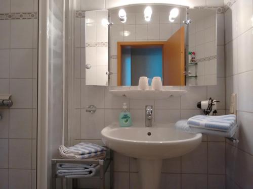 W białej łazience znajduje się umywalka i lustro. w obiekcie Ferienwohnungen Ricken w mieście Willingen