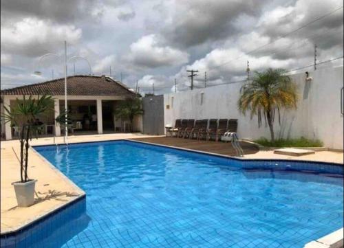 una gran piscina azul frente a un edificio en Quarto em casa de condominio fechado en Santarém