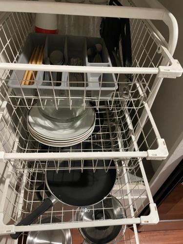a wire dish rack with plates and utensils at Tao house in La Verne