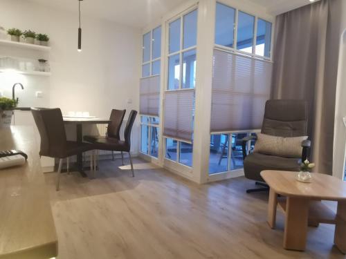 a living room with a dining room table and chairs at Apartmenthaus Atlantik in Kühlungsborn