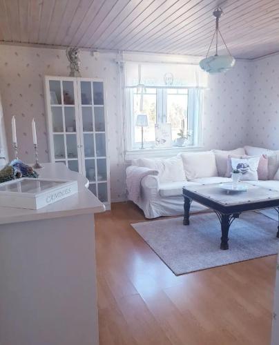 a living room with a white couch and a table at Höhällets Lantliga Rum in Värnamo