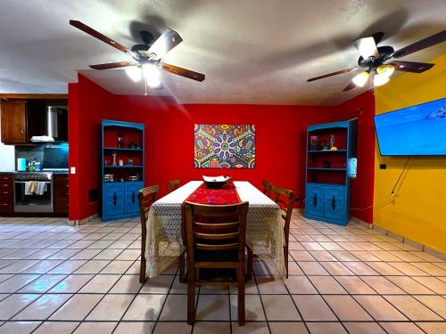 a kitchen with a table and a red wall at Casa Revolucion: 2BR/2Ba Casita close to downtown with private parking in Cabo San Lucas