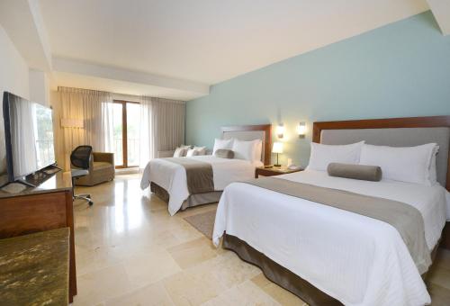 um quarto de hotel com duas camas e uma televisão de ecrã plano em HB Xalapa em Xalapa