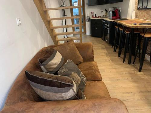 a living room with a couch with pillows on it at Maison centre-ville Cambrai in Cambrai