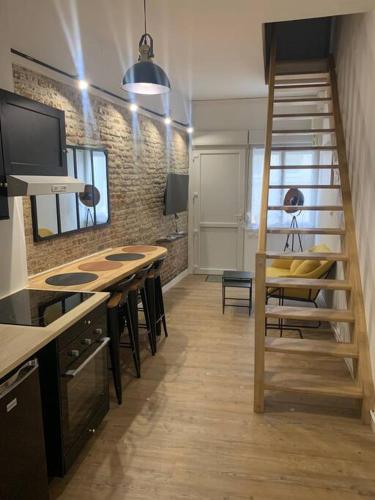 une chambre avec un escalier et une cuisine avec une table et des chaises dans l'établissement Maison centre-ville Cambrai, à Cambrai